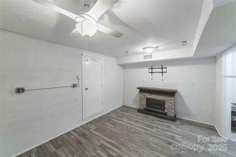 a room view with fireplace and a ceiling fan