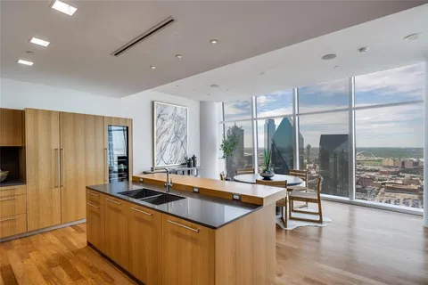 a kitchen with stainless steel appliances granite countertop a sink a stove and a wooden floors