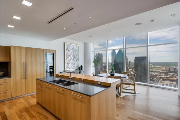 a kitchen with stainless steel appliances granite countertop a sink a stove and a wooden floors