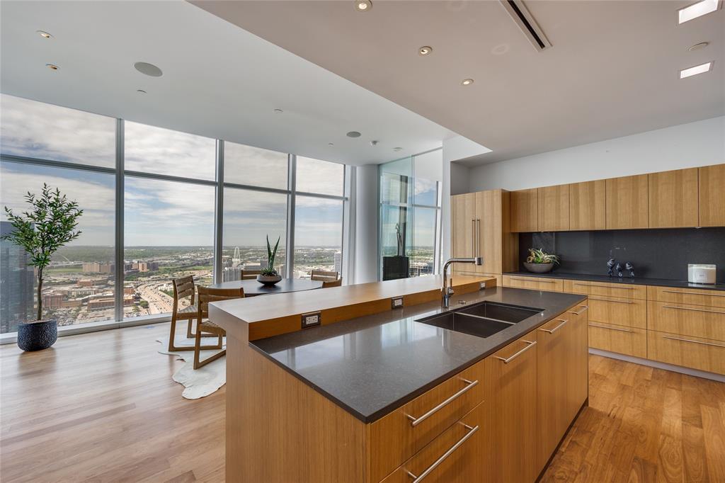1918 Olive Street, Unit 3601 Dallas, TX 75201 - Photo 12 of 39 a kitchen with stainless steel appliances granite countertop a sink a stove and a wooden floors