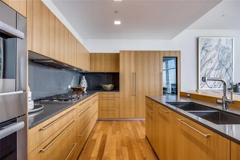 a kitchen with stainless steel appliances kitchen island granite countertop a sink and cabinets