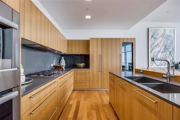 a kitchen with stainless steel appliances kitchen island granite countertop a sink and cabinets