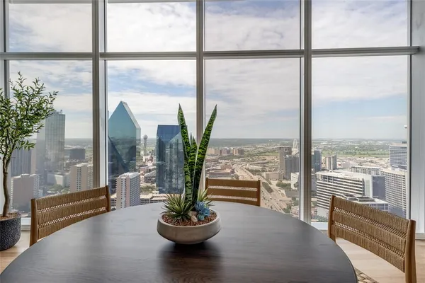 a living room with furniture potted plant and a large window