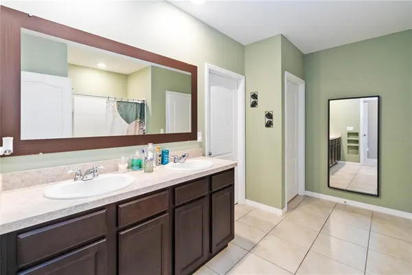 a en suite bathroom with a double vanity sink and a mirror