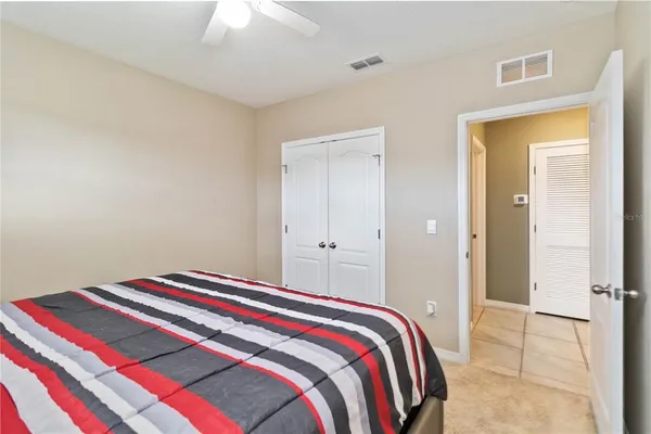 a bedroom with a bed and a chandelier fan