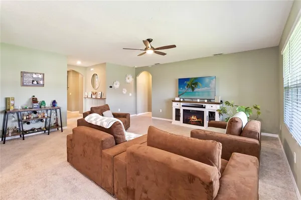 a living room with furniture a fireplace and a large window