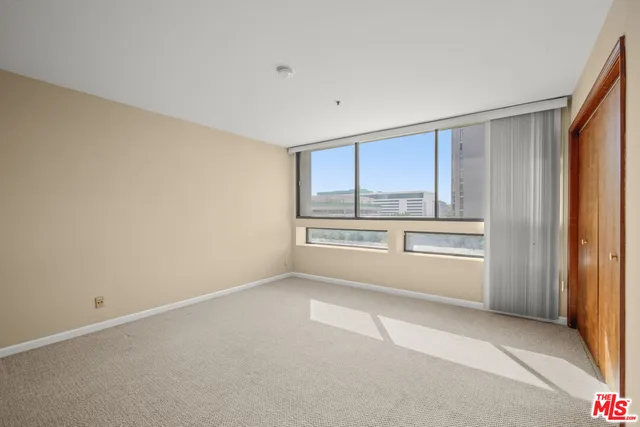 a view of a big room with wooden floor and windows
