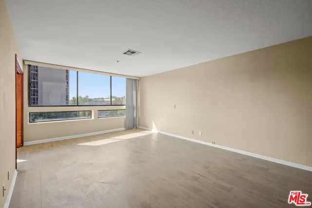 a view of an empty room with a kitchen