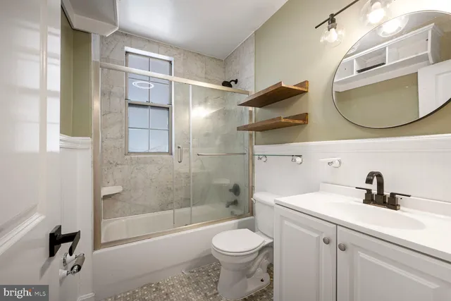 a bathroom with a sink a toilet and a mirror