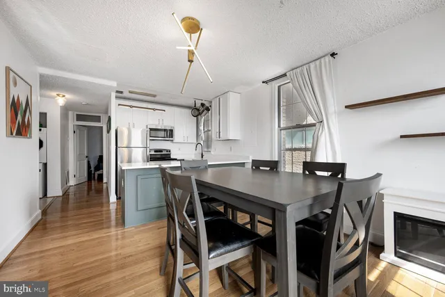 a kitchen with stainless steel appliances a table chairs and entryway