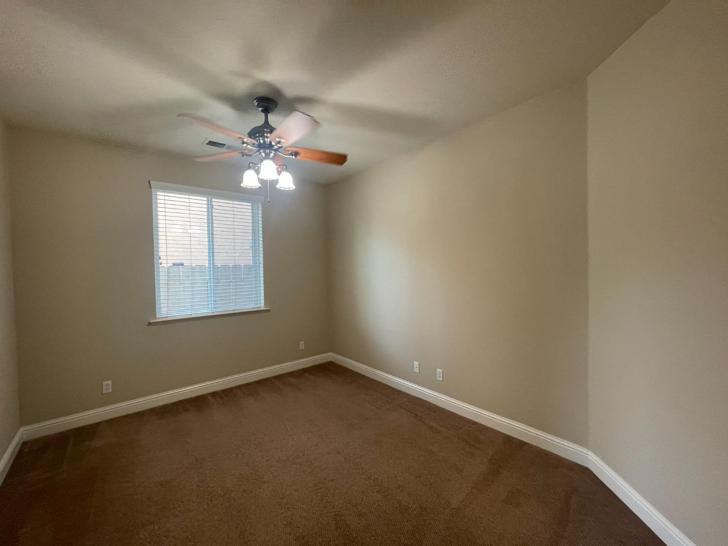 2616 Goshen Avenue Clovis, CA 93611 - Photo 15 of 39 an empty room with a window and a fan