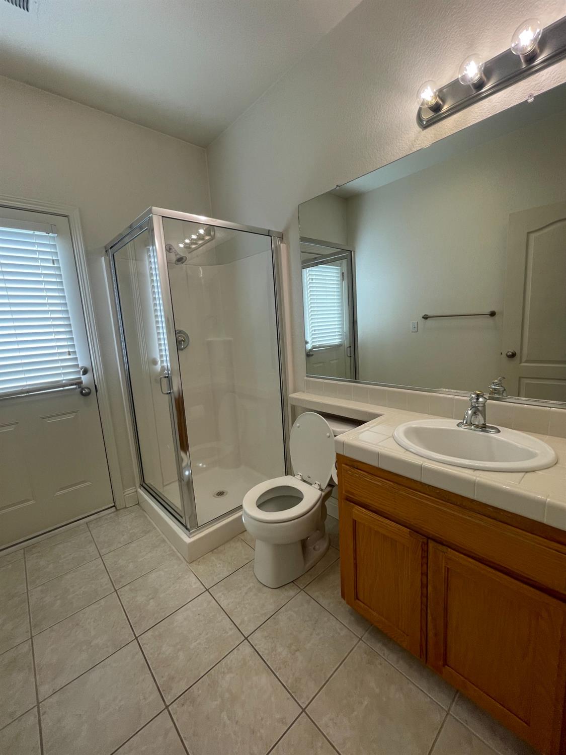 2616 Goshen Avenue Clovis, CA 93611 - Photo 18 of 39 a bathroom with a granite countertop sink a toilet and a mirror