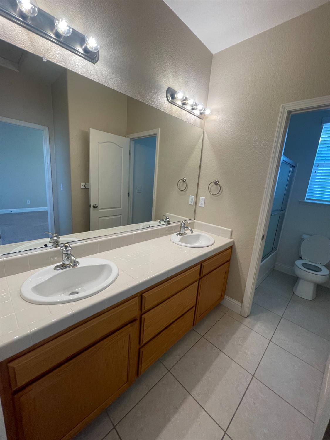2616 Goshen Avenue Clovis, CA 93611 - Photo 27 of 39 a bathroom with a double vanity sink and a mirror