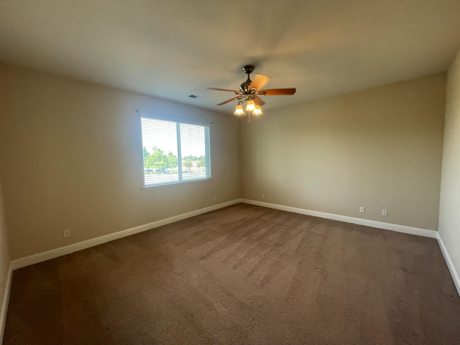 2616 Goshen Avenue Clovis, CA 93611 - Photo 32 of 39 an empty room with windows and chandelier fan