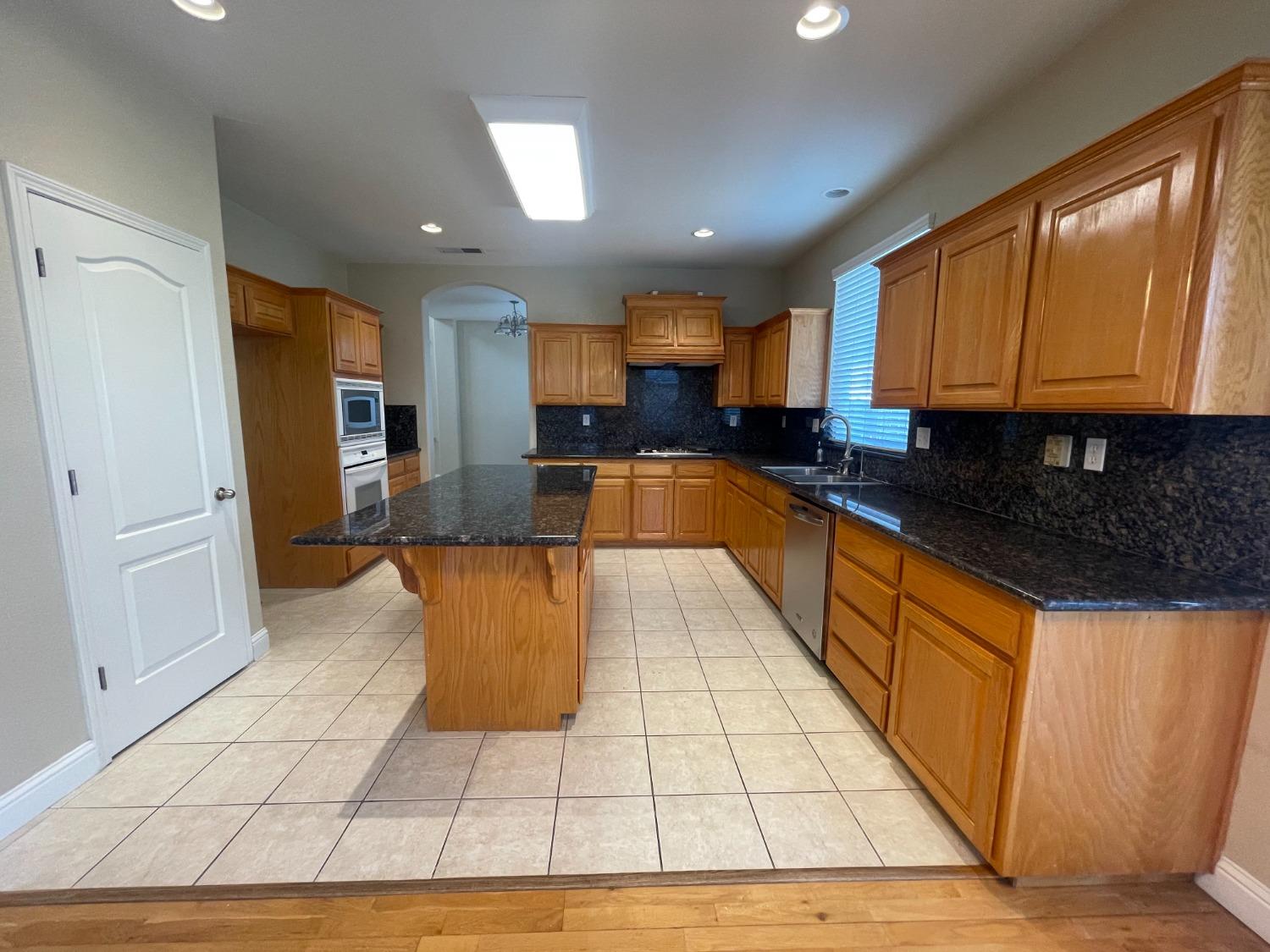 2616 Goshen Avenue Clovis, CA 93611 - Photo 7 of 39 a kitchen with granite countertop a stove a sink and a refrigerator