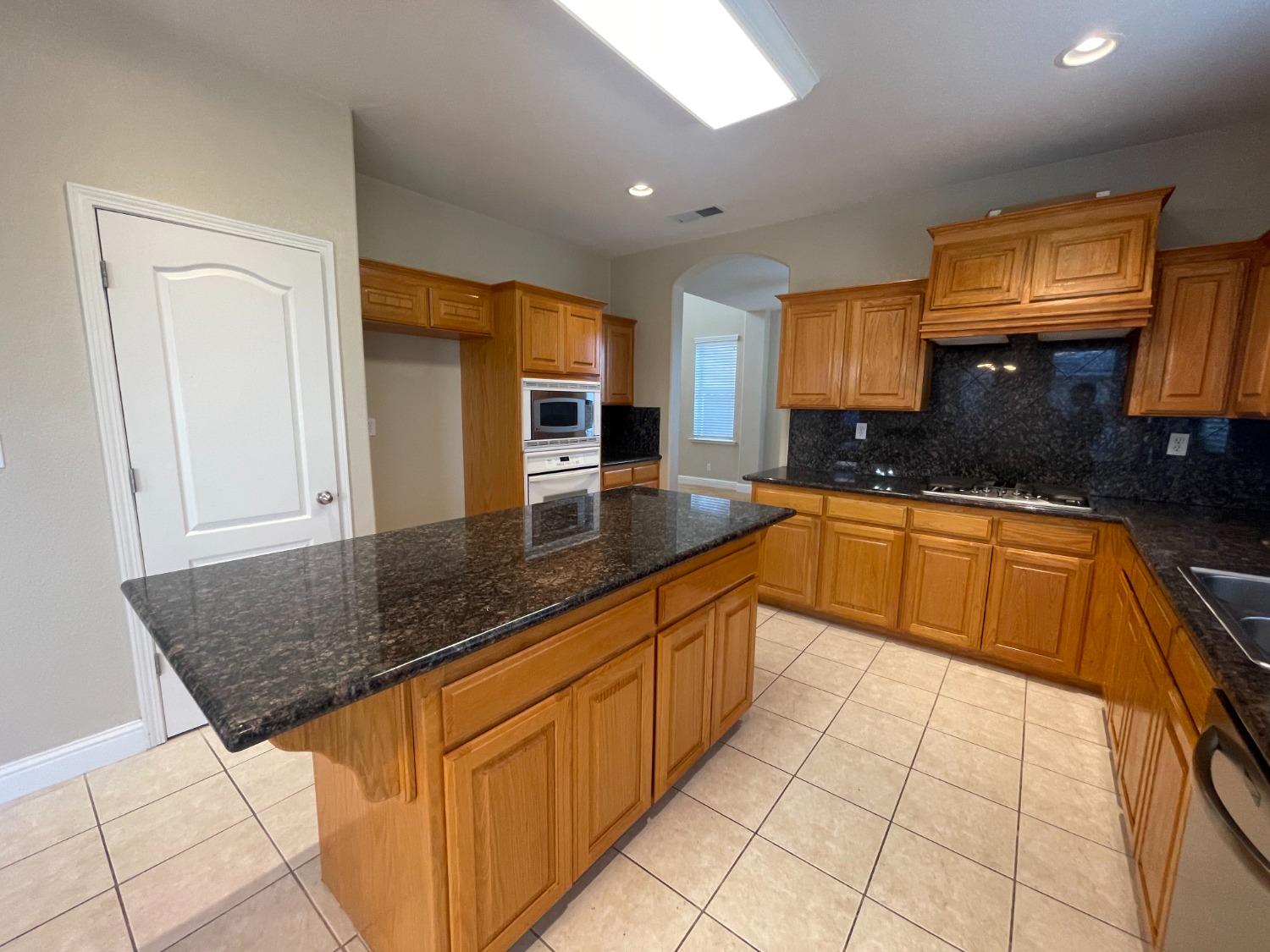 2616 Goshen Avenue Clovis, CA 93611 - Photo 10 of 39 a kitchen with stainless steel appliances granite countertop a sink stove and cabinets