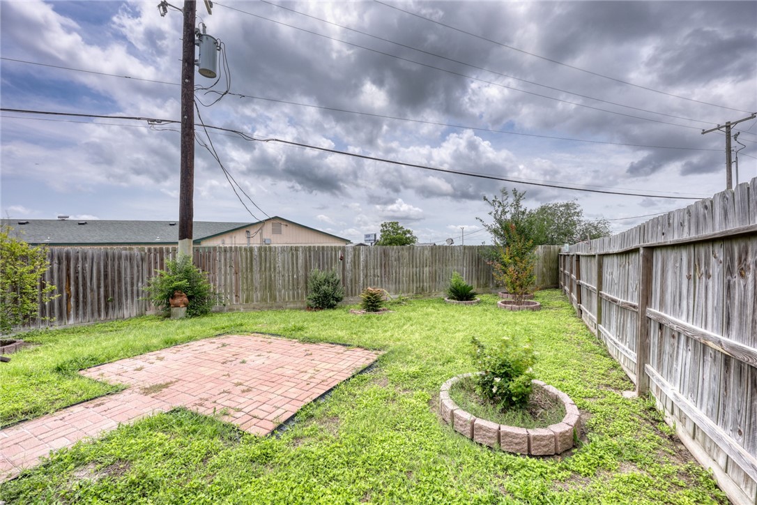 302 Cooper Road, Unit E2 Odem, TX 78370 - Photo 20 of 24 a view of a backyard with wooden fence