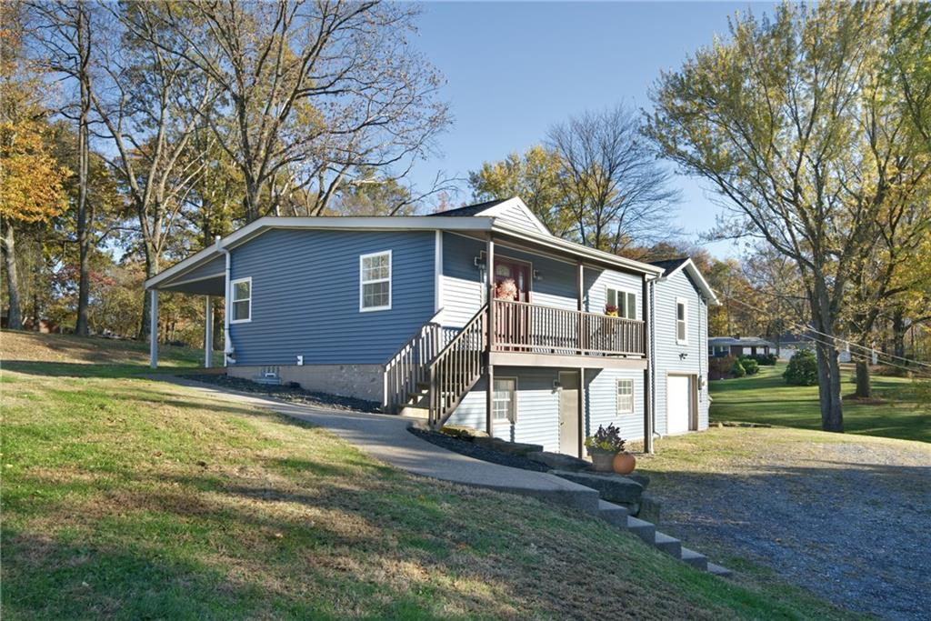 a front view of house with yard and trees in the background