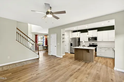 a kitchen with stainless steel appliances kitchen island hardwood floor and a sink