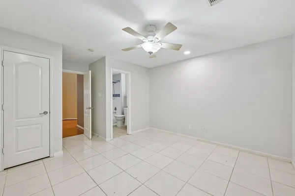 an empty room with closet and fan