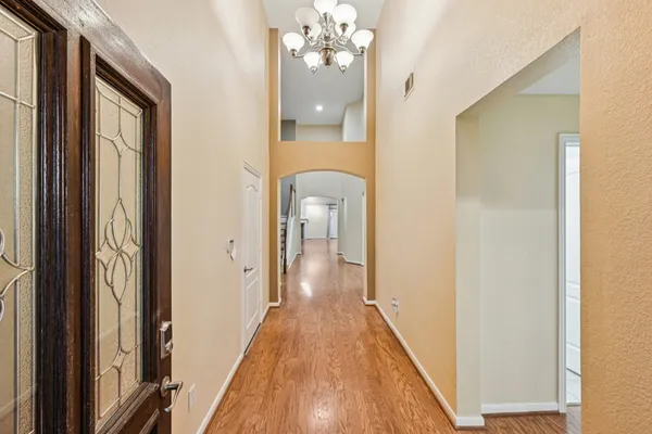 a view of a hallway with wooden floor and staircase