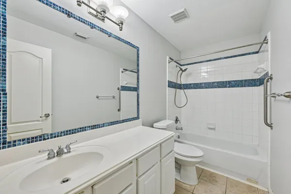 a bathroom with a granite countertop sink a toilet and shower