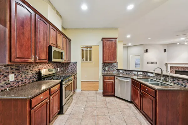 a kitchen with stainless steel appliances granite countertop a sink stove and cabinets