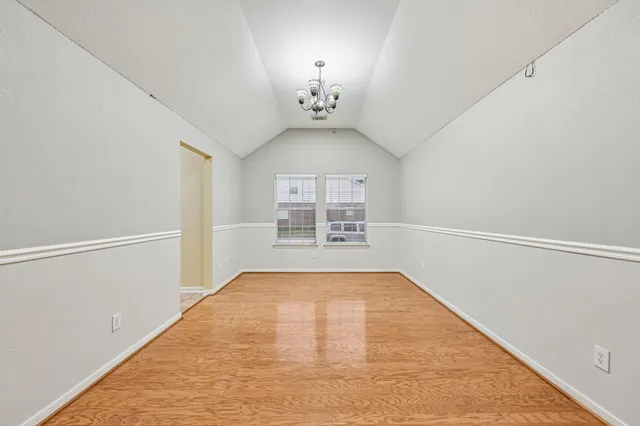 a view of a room with wooden floor and a window