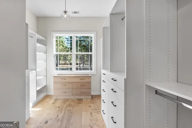 an empty room with closet and windows