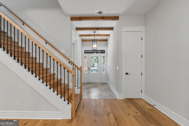 a view of a hallway with wooden floor and entryway