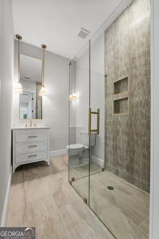 a view of an empty room and kitchen with furniture wooden floor kitchen view and a window