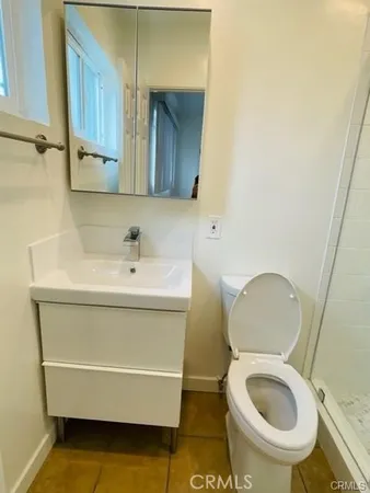 a bathroom with a toilet a sink and mirror