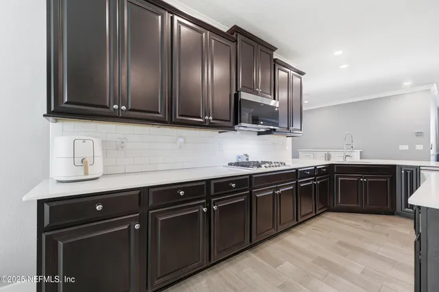 a large kitchen with kitchen island a sink stainless steel appliances and cabinets