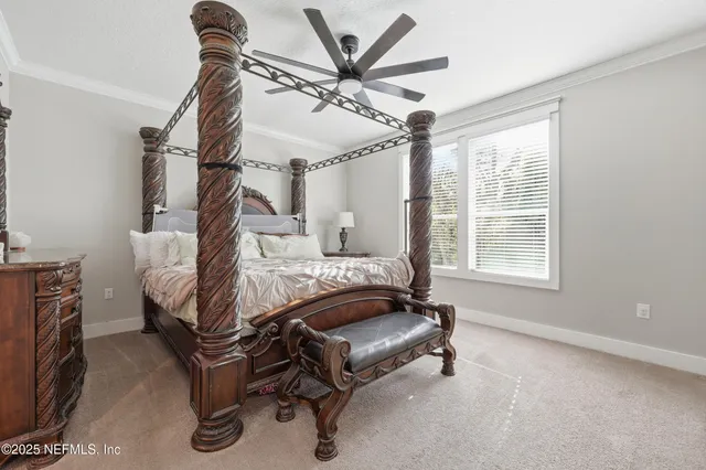 a bed sitting in a bedroom next to a window and a chandelier