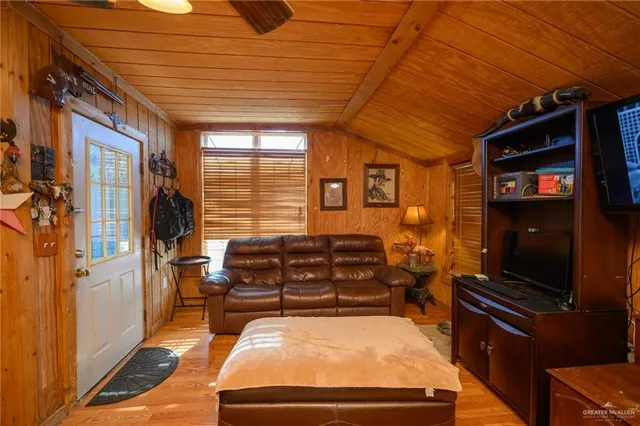 a room with furniture pool table flat screen tv and windows