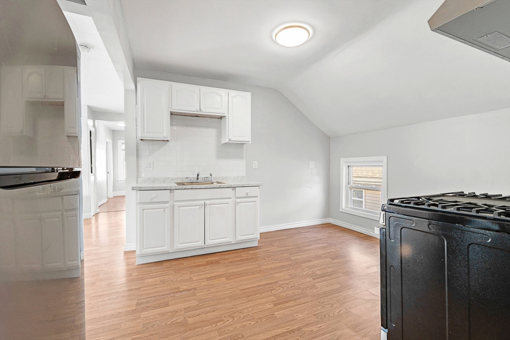 502 4th Street Fall River, MA 02721 - Photo 16 of 34 a kitchen with granite countertop a refrigerator and a stove top oven