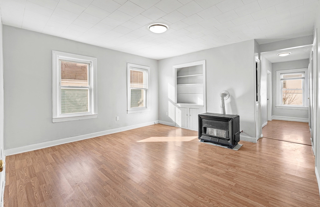 502 4th Street Fall River, MA 02721 - Photo 21 of 34 an empty room with windows fireplace and wooden floor