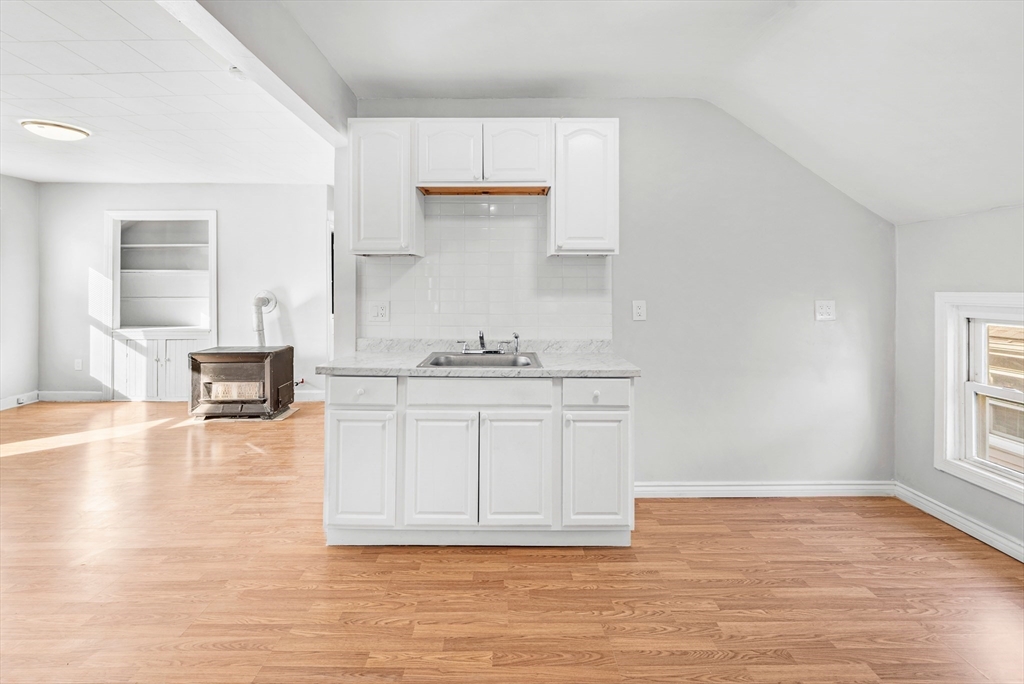 502 4th Street Fall River, MA 02721 - Photo 6 of 34 a view of a kitchen with granite countertop white cabinets and wooden floor