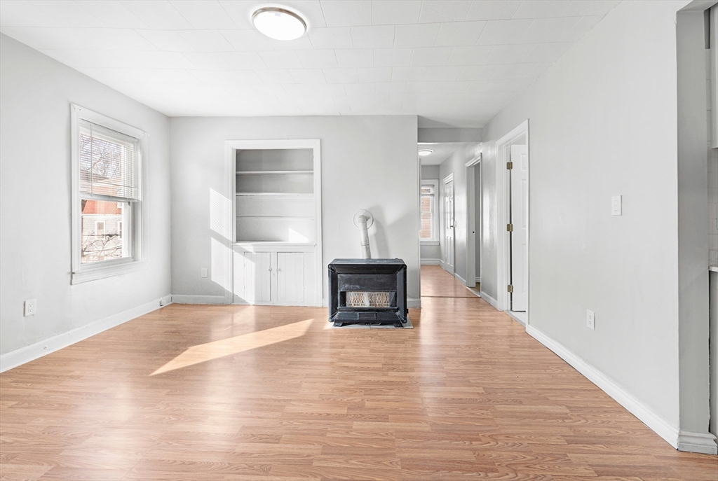 502 4th Street Fall River, MA 02721 - Photo 9 of 34 a view of empty room with wooden floor and fireplace