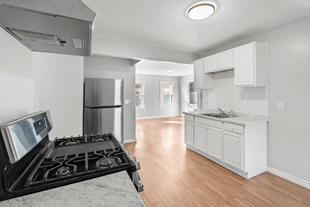 502 4th Street Fall River, MA 02721 - Photo 10 of 34 a kitchen with granite countertop a stove and a refrigerator