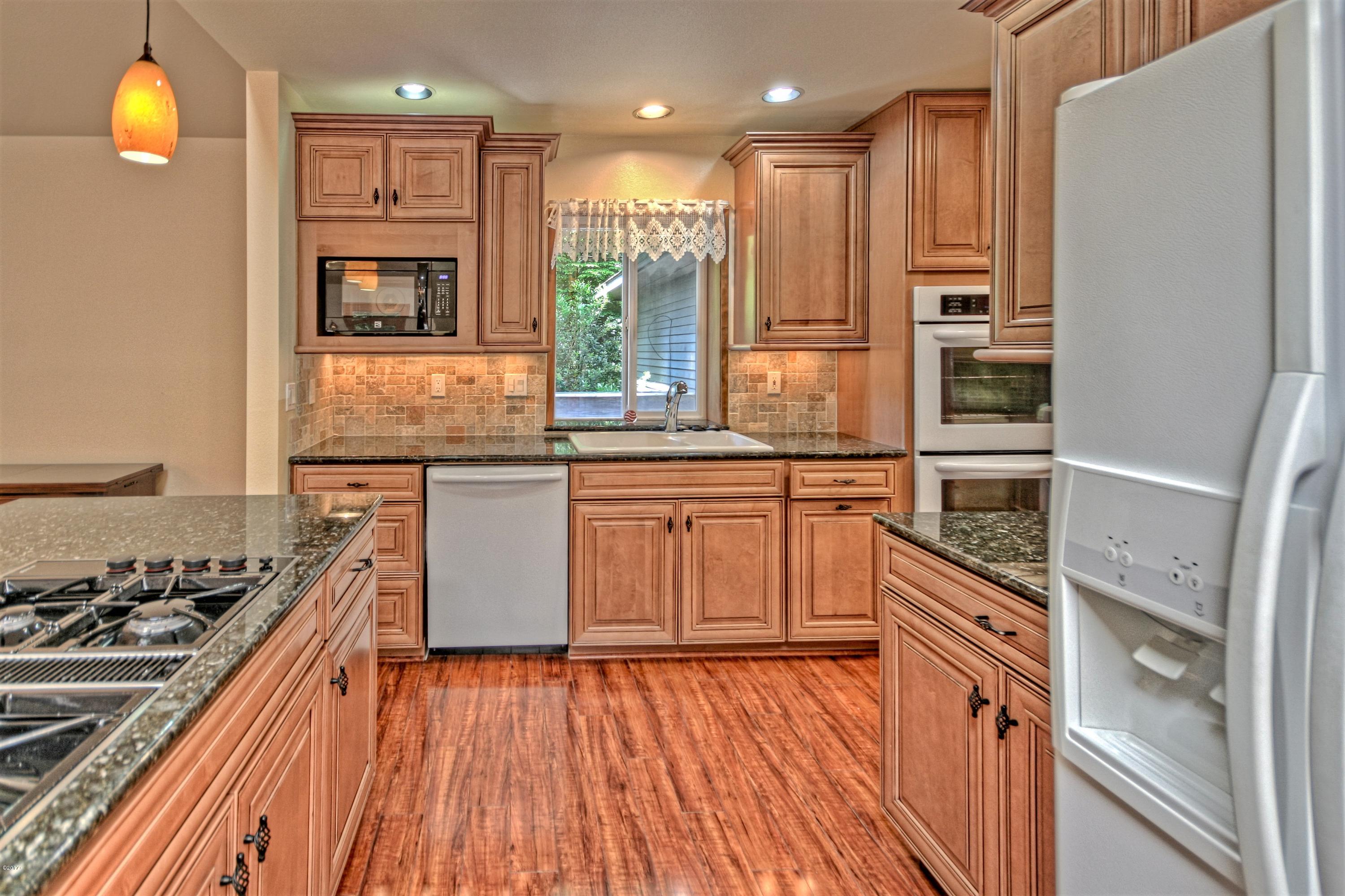 17 Big Tree Road Gleneden Beach, OR 97388 - Photo 9 of 52 a kitchen with stainless steel appliances granite countertop a stove and a refrigerator