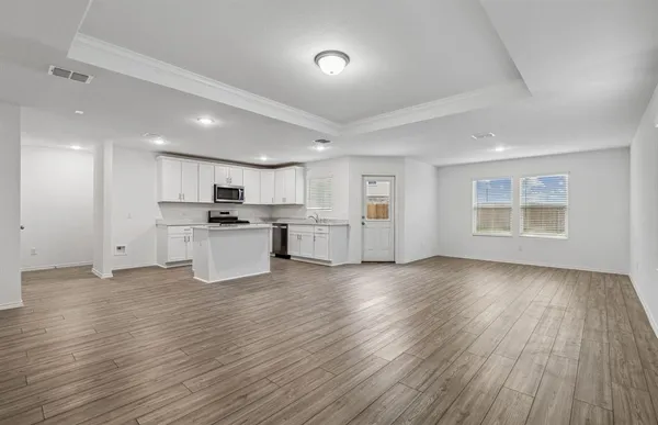 a view of kitchen with wooden floor and electronic appliances