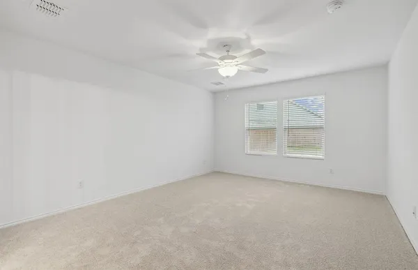an empty room with a window and a ceiling fan