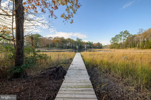 a view of a house with a wooden fence and a floor to ceiling window