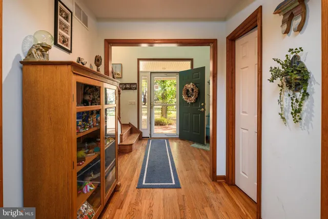 a view of a hallway with wooden floor and a livingroom