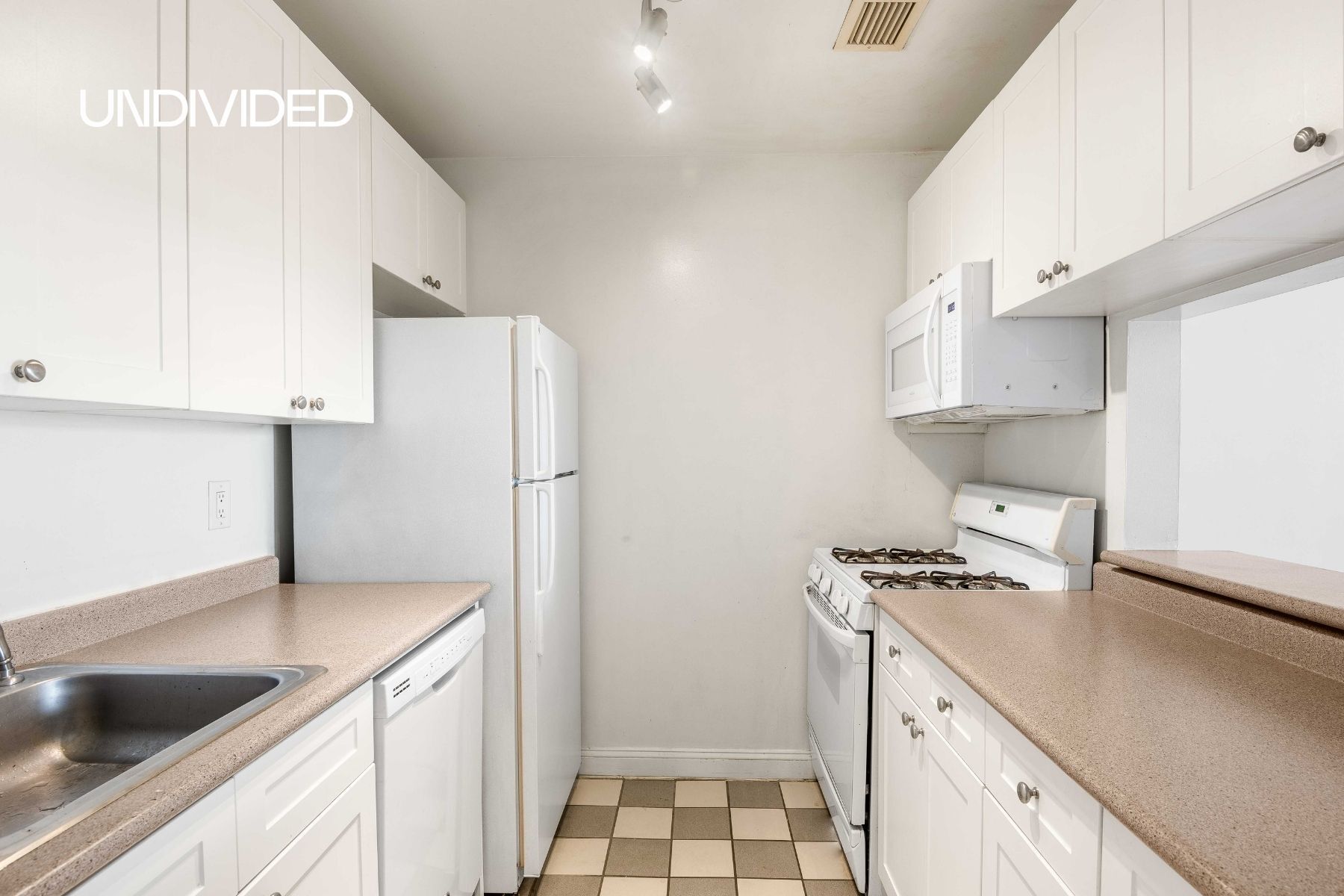 Undisclosed Address Manhattan, NY 10006 - Photo 4 of 9 a kitchen with stainless steel appliances a refrigerator a sink and white cabinets