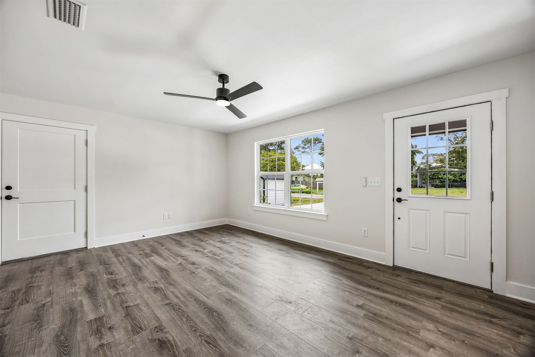 552 Sunset Road Fernandina Beach, FL 32034 - Photo 3 of 23 a view of empty room with wooden floor and fan