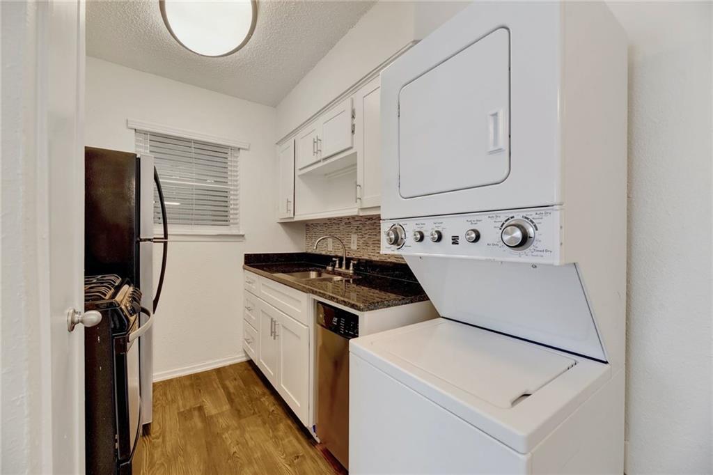 2401 Manor Road, Unit 221 Austin, TX 78722 - Photo 12 of 21 Compact and efficient kitchen with modern appliances and durable wood-look flooring.
