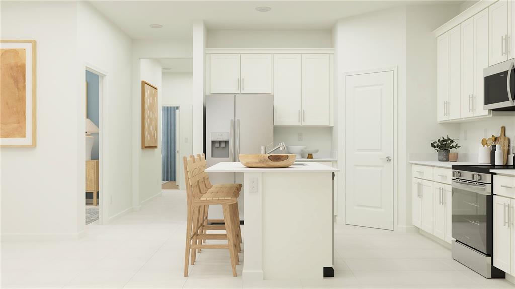 4249 Curacao Place Kissimmee, FL 34758 - Photo 3 of 30 a kitchen with a refrigerator a stove cabinets and a dining table