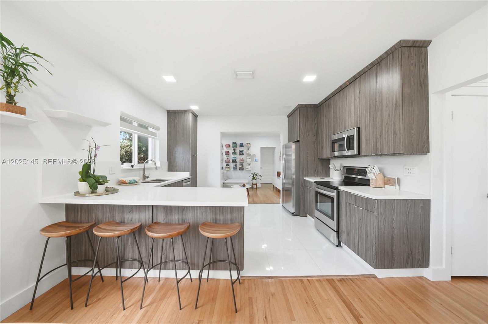 3101 Southwest 25th Terrace Miami, FL 33133 - Photo 6 of 31 a large kitchen with kitchen island granite countertop a wooden floor and cabinets